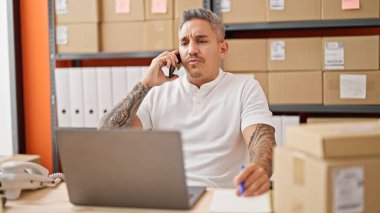 Genç İspanyol bir iş adamı ofisteki akıllı telefondan konuşuyor.