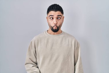 Soyutlanmış arka planda duran genç yakışıklı adam dudaklarıyla balık suratı yapıyor, çılgınca ve komik bir jest. Komik ifade. 