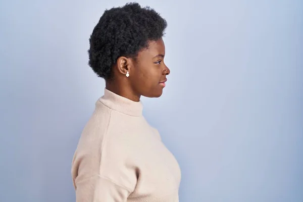Afroamerikanerin Steht Über Blauem Hintergrund Und Schaut Zur Seite Entspannte — Stockfoto