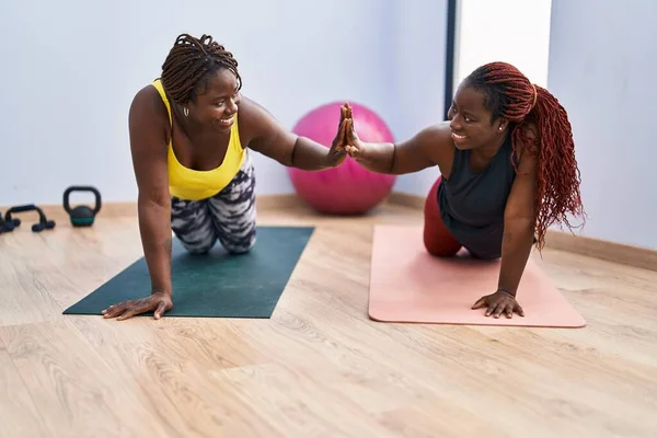 在体育中心训练腹肌的非裔美国妇女练高五 — 图库照片