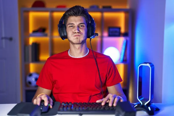 Young Hispanic Man Playing Video Games Puffing Cheeks Funny Face — Foto Stock