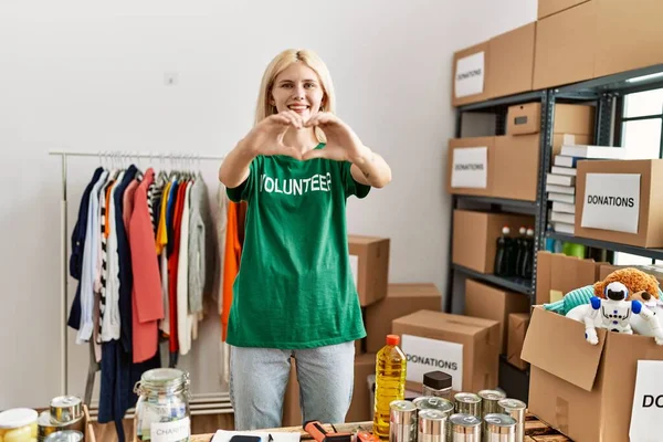 Young Blonde Woman Volunteer Doing Heart Gesture Smiling Charity Center — Stock Photo, Image