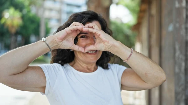 Středověká Hispánská Žena Usmívá Sebevědomě Dělá Srdeční Gesto Rukama Parku — Stock fotografie