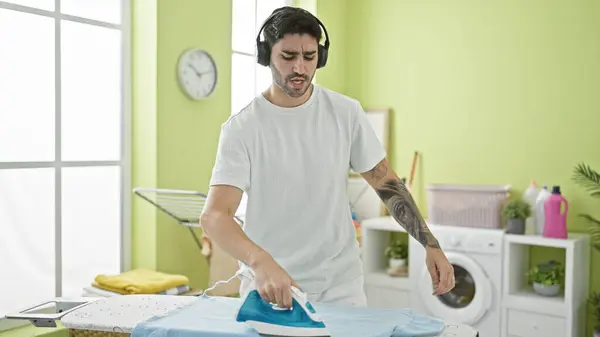 Ung Latinamerikansk Man Lyssnar Musik Strykning Kläder Tvättstuga — Stockfoto