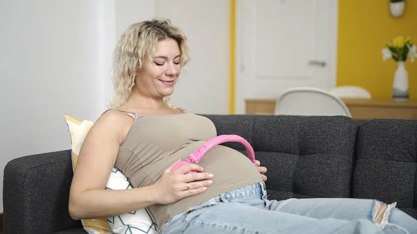 Genç Hamile Bir Kadın Gülümsüyor Kulaklıklarını Evde Takıyor — Stok fotoğraf