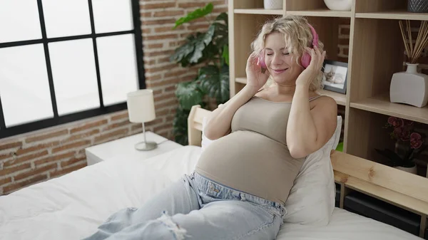 Genç Hamile Kadın Yatak Odasında Oturmuş Müzik Dinliyor — Stok fotoğraf