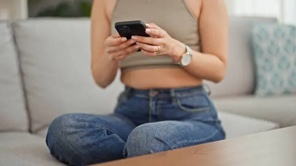 Nuori Kaunis Latino Nainen Käyttää Älypuhelinta Istuu Sohvalla Kotona — kuvapankkivalokuva