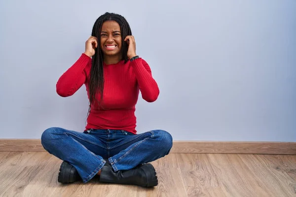 Mladý Africký Američan Copánky Sedícími Doma Podlaze Zakrývajícími Uši Prsty — Stock fotografie