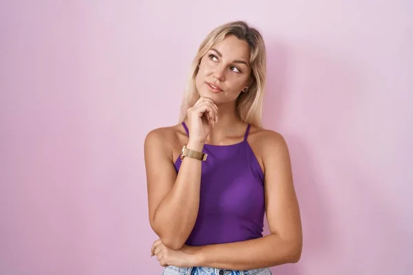 Young Blonde Woman Standing Pink Background Hand Chin Thinking Question — Foto Stock