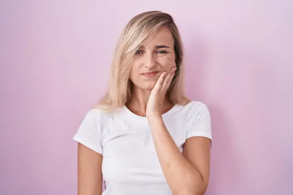 Young Blonde Woman Standing Pink Background Touching Mouth Hand Painful — Zdjęcie stockowe