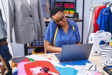 Terzide bilgisayarla konuşan Afro-Amerikalı kadın terzi.