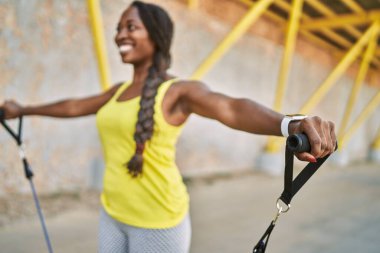 African american woman using elastic band training at street