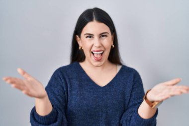 Genç esmer kadın, izole edilmiş arka planda gülümseyen, yardım eli uzatan ve kabullenen bir kadın.. 