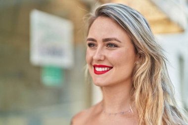 Young beautiful hispanic woman smiling confident looking to the side at street