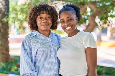 African american women mother and daughter standing together at park