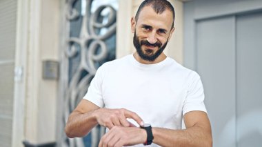 Genç İspanyol adam gülümsüyor. Kendine güveni tam, sokağı izliyor.