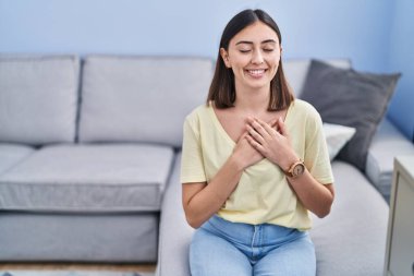 Genç İspanyol kadın elleriyle kalbe dokunuyor.