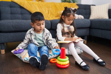 Sevimli çocuk ve kız evdeki defterde çember oyunu oynuyor.