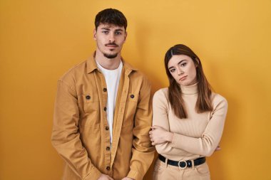 Sarı arka planda duran genç İspanyol çift uykulu ve yorgun görünüyor, yorgunluktan bitkin ve akşamdan kalma, sabahları tembel gözler.. 