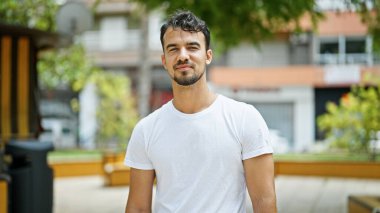 Parkta kendinden emin gülümseyen İspanyol genç adam.