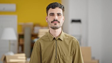 Yeni evinde ciddi yüzüyle duran Latin asıllı genç adam.