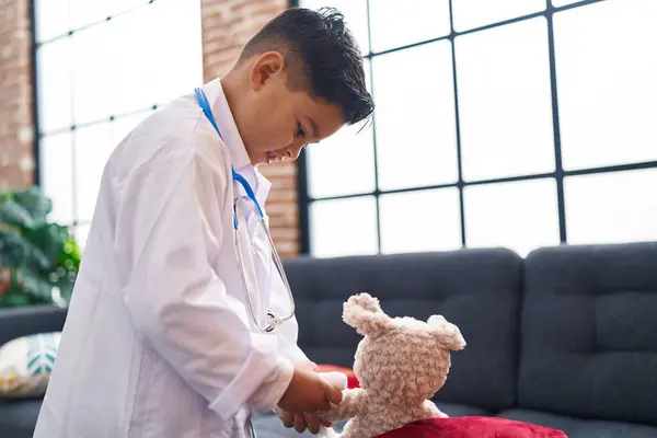 Adorable Hispanic Boy Wearing Doctor Uniform Examining Teddy Bear Home — Stock Photo, Image