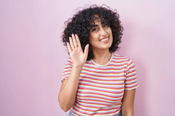 年轻的中东女人站在粉红的背景前 等待打招呼 开心而微笑 友好地欢迎你的举动 — 图库照片