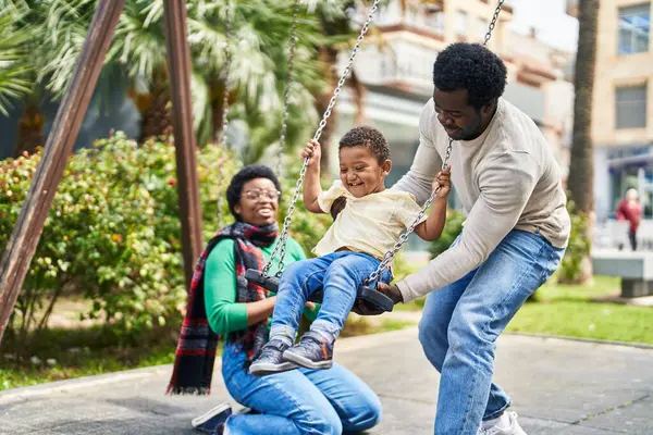 非裔美国人家庭在操场上荡秋千 — 图库照片