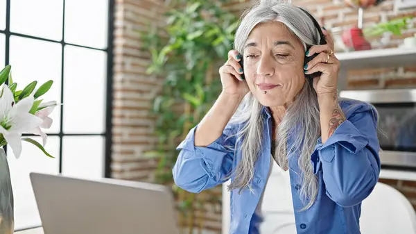 Mujer Pelo Gris Mediana Edad Usando Laptop Auriculares Comedor —  Fotos de Stock