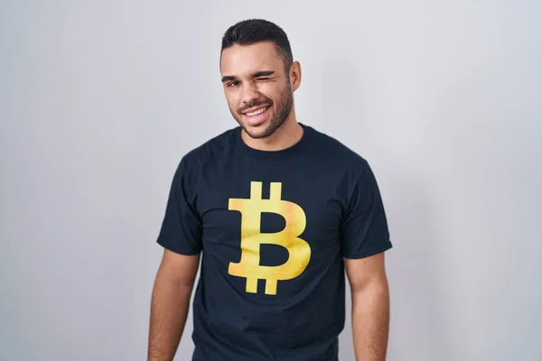 Joven Hombre Hispano Vistiendo Camiseta Bitcoin Guiño Mirando Cámara Con —  Fotos de Stock