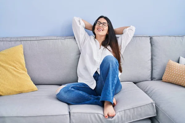 Young Hispanic Woman Relaxed Hands Head Sitting Sofa Home — Foto Stock