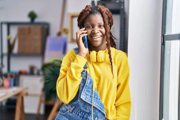 stock image African american woman artist talking on smartphone standing at art studio