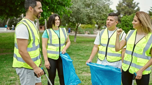 Group of people volunteers speaking to collect trash at park