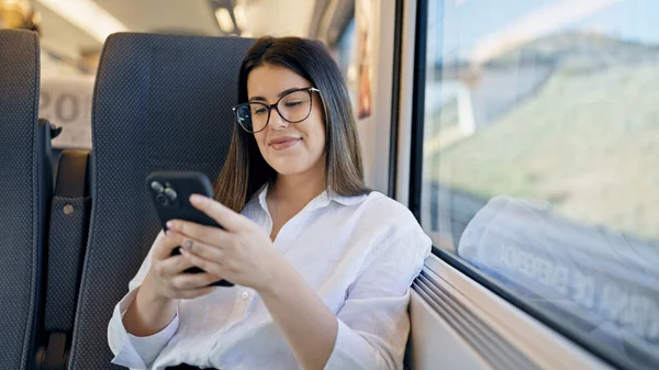 Joven Hermosa Mujer Hispana Sonriendo Usando Teléfono Inteligente Sentado Dentro — Foto de Stock