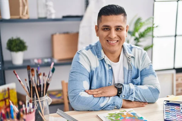 Jonge Latijnse Man Kunstenaar Glimlachend Zelfverzekerd Zitten Met Armen Gekruist — Stockfoto