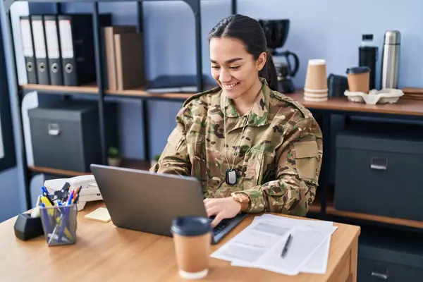 Young hispanic woman army soldier using laptop at office