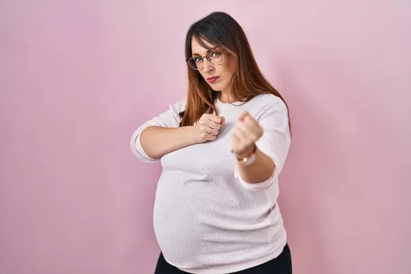 孕妇站在粉红的背景下拳打脚踢打斗 攻击性和愤怒的攻击 威胁和暴力 — 图库照片