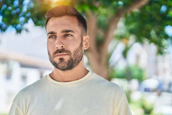 stock image Young hispanic man looking to the side with serious expression at park