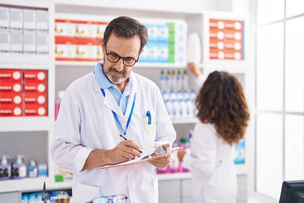 Man Woman Pharmacists Writing Document Working Pharmacy — Stock Photo, Image