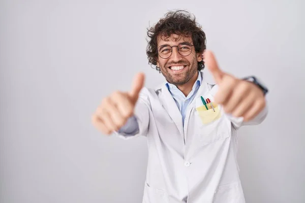 Jovem Hispânico Vestindo Uniforme Médico Aprovando Fazer Gesto Positivo Com — Fotografia de Stock
