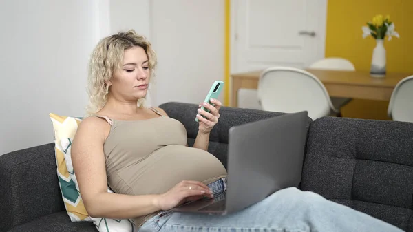 Jonge Zwangere Vrouw Met Behulp Van Smartphone Laptop Liggend Bank — Stockfoto