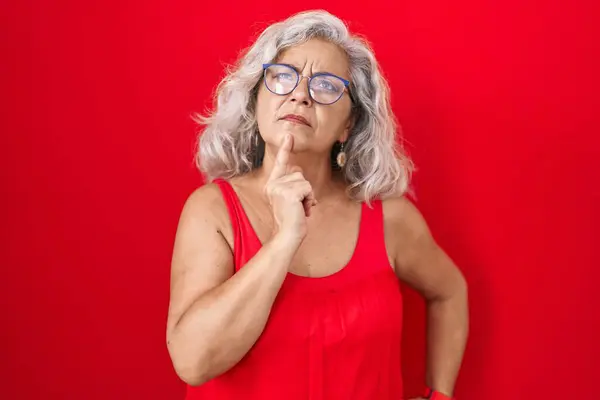 Kırmızı Arka Planda Gri Saçlı Orta Yaşlı Bir Kadın Parmak — Stok fotoğraf