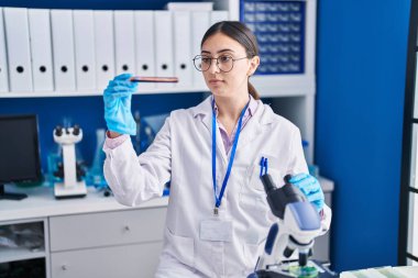 Laboratuvarda kan tahlili tüpü tutan genç İspanyol bilim kadını.