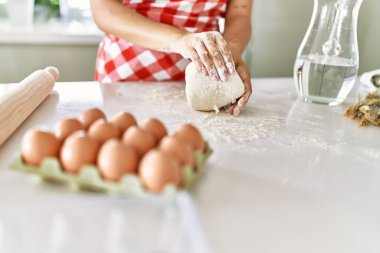Genç ve güzel İspanyol kadın mutfakta elleriyle ekmek hamuru yoğuruyor.