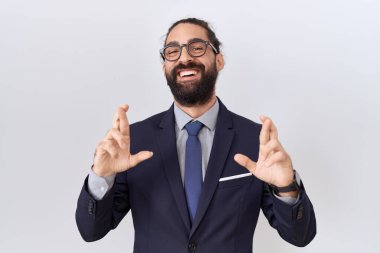 Sakallı, takım elbiseli ve kravatlı İspanyol bir adam umut ve gözleri kapalı gülümseyerek el sallıyor. Şans ve batıl inançlar. 