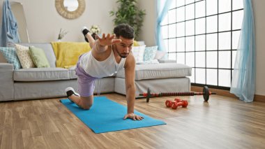 Genç Arap adam evde çekirdek egzersizi yapıyor.