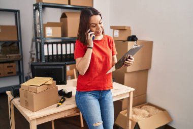 Genç, güzel, İspanyol bir kadın. İşadamı, ofisteki akıllı telefon okuma belgeleriyle konuşuyor.