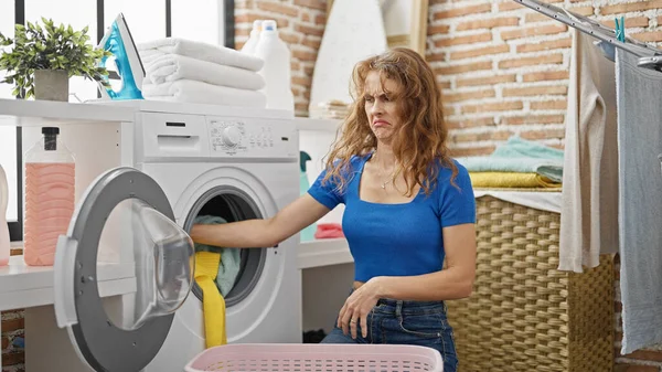 洗濯室で洗濯する若い女性 — ストック写真