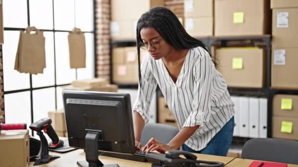 アフリカ系アメリカ人の女性がオフィスに立ってコンピュータを使ってビジネスワーカーをEコマース — ストック動画