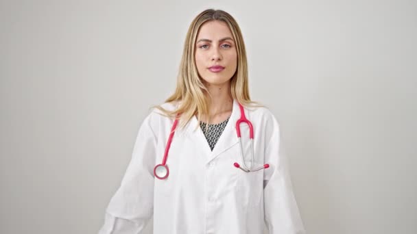 若いですブロンド女性医師作り誓いとともに手上の胸上の隔離された白い背景 — ストック動画